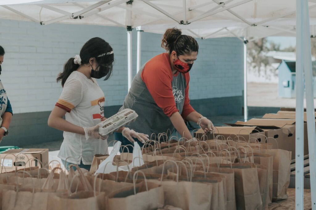 a group of colleagues volunteering and filling bags with items to give to those in need