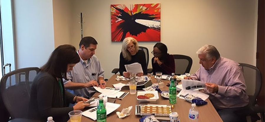 five colleagues doing a custom charity team building event together at a table