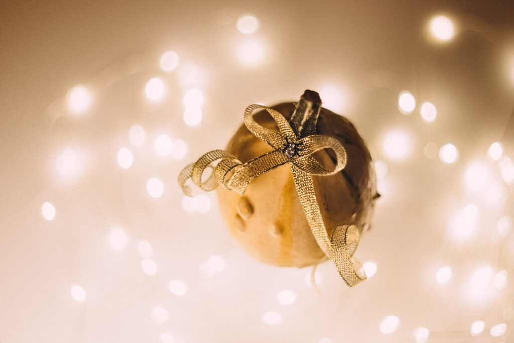 Holiday-themed team building questions section image with gold ornament and abstract lighting